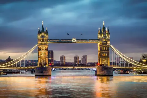 Wieczorna panorama Mostu Tower Bridge w Londynie z oświetlonymi wieżami i rzeką Tamizą.