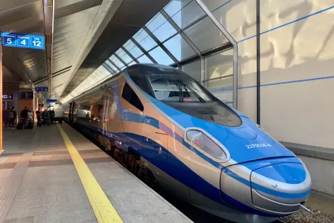 Nowoczesny pociąg InterCity w kolorach niebieskim i srebrnym stoi na peronie.