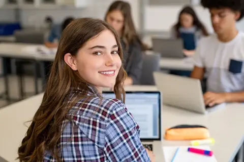Schülerinnen und Schüler im Deutschunterricht, die an Laptops arbeiten. Ein Beispiel für ein interview schreiben.