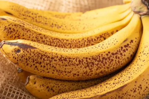 Kilka dojrzałych bananów z brązowymi plamkami. Zastanawiasz się, ile węglowodanów ma banan?