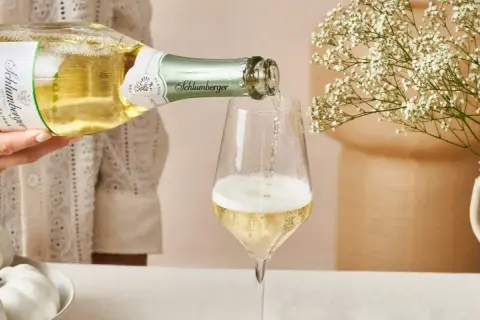Schlumberger Grüner Veltliner Sekt wird ins Glas gegossen. Der Prosecco hat einen angenehmen prozentualen Alkoholgehalt.