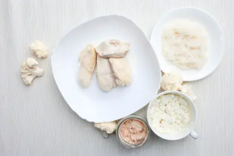 Biała dieta przepisy: gotowany kurczak, ryż, kalafior, twaróg i pasztet rybny na białym obrusie.