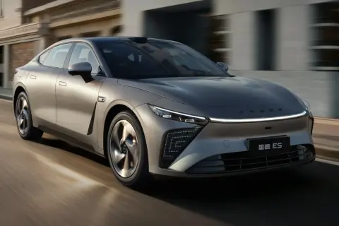 Srebrny sedan Exlantix ES pędzi ulicą, jego futurystyczny design przyciąga wzrok.