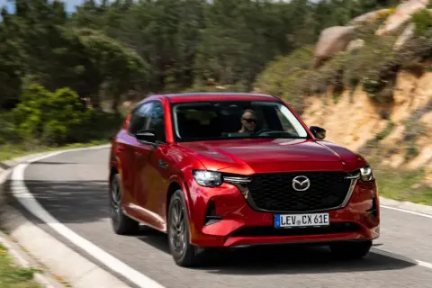 Czerwona Mazda CX-60 na krętej drodze. Poznaj jej imponujące mazda cx 60 wymiary i ciesz się jazdą.