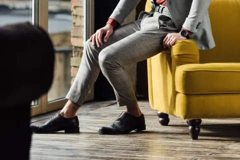 Eleganckie, ciemne buty męskie do szarego garnituru w kratę. Stylowa inspiracja.