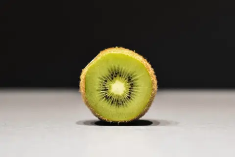Połówka kiwi, idealna na keto, z widocznymi czarnymi pestkami i zielonym miąższem.
