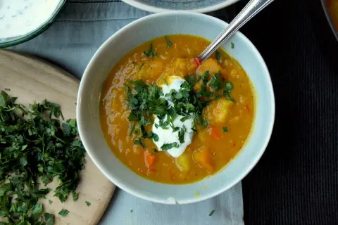 Herzhafte Linsensuppe mit einem Klecks Joghurt und frischer Petersilie, ein köstliches Gericht für kalte Tage.