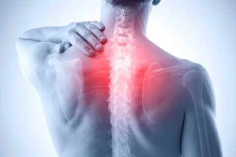 Uomo con mano sulla spalla, evidenziata zona rossa sulla colonna vertebrale, indicando dolore muscolare schiena alta.