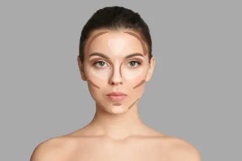 Modelka pokazuje, gdzie nakładać bronzer i rozświetlacz, by wymodelować twarz. Linie na policzkach, czole i nosie.