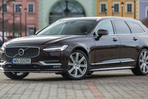 Brązowe Volvo V90 na tle kamienic. Sprawdź akcje serwisowe Volvo po VIN, aby upewnić się, że Twój samochód jest bezpieczny.