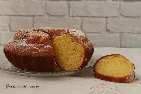 Torta soffice da cucina, spolverata di zucchero a velo. Un profumo che ricorda il burro di cacao.