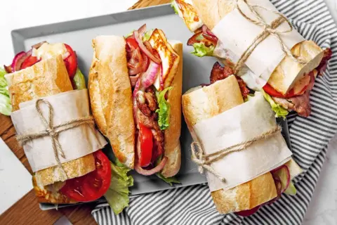 Leckere Sandwich-Rezepte: Baguettes gefüllt mit Halloumi, Speck, Tomaten, Zwiebeln und Salat.