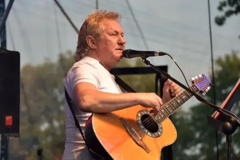 Janusz Laskowski śpiewa i gra na gitarze podczas kolorowych jarmarków.