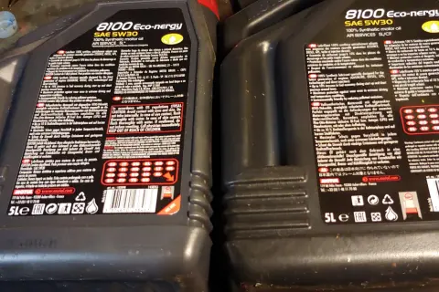 Dwie czarne butelki oleju silnikowego Motul 8100 Eco-nergy SAE 5W30 z etykietami w języku polskim i angielskim.