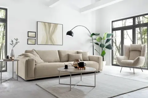 Gemütliches Wohnzimmer mit beigem Sofa, Sessel und Couchtisch. Tolle wohnideen modern für ein stilvolles Zuhause.