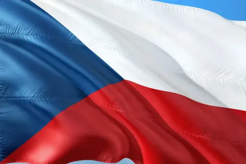 Flaga Czech falująca na wietrze. Kraj ten słynie z piwa, ale warto pamiętać o **Czechy limit alkoholu**, by cieszyć się podróżą.