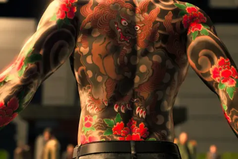 Yakuza tatuaże zdobią plecy i ramiona mężczyzny. Widoczny jest potężny lew i czerwone kwiaty peonii, symbolizujące siłę i bogactwo.