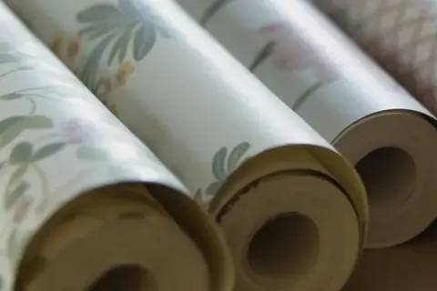 Rullar med tapet i olika mönster. Frågan om hur många våder på en tapetrulle är relevant för att beräkna materialåtgången.