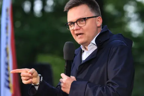 Mężczyzna w okularach przemawia do mikrofonu, wskazując palcem. Czy to przyszła struktura elektoratu polska 2050? Kto głosuje na Hołownię?