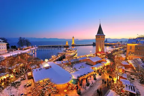 Winterzauber am Hafenweihnacht Lindau: Lichterglanz, Schnee und Menschenmassen vor dem alten Wasserturm und den Leuchttürmen.