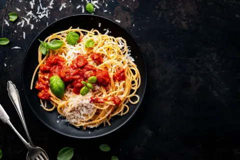 Ein Teller Spaghetti mit Tomatensauce, Parmesan und Basilikum. Perfekt für vegetarische italienische Pasta Rezepte.