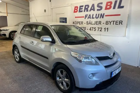Silver Toyota Urban Cruiser, möjligen med ett mindre problem, står parkerad framför en bilfirma i Falun.