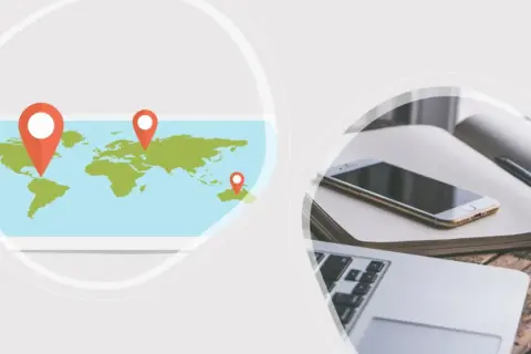 Weltkarte mit Markierungen für einen Deutschland-Trip. Daneben ein Laptop, Smartphone und Notizbuch.