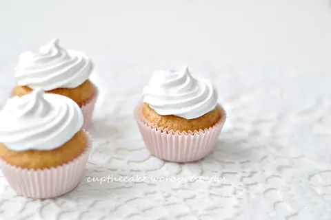 Tre fluffiga muffins med vit frosting, perfekta för ett enkelt frosting recept.