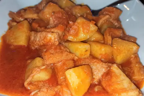 Un saporito piatto di trippa con patate, cotto in un ricco sugo di pomodoro.