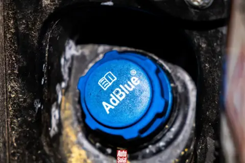 Niebieski korek wlewu AdBlue, z napisem "AdBlue" i symbolem książki. Czy adblue zamarza? To pytanie nurtuje wielu kierowców zimą.