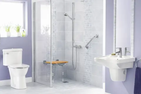 Bagno disabili con doccia a filo pavimento, sedile ribaltabile, maniglioni e WC rialzato per maggiore comfort e sicurezza.