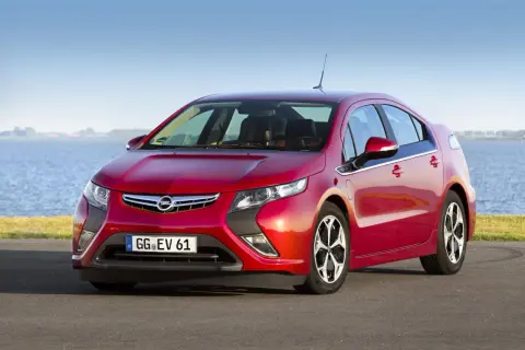 Czerwony Opel Ampera stoi nad jeziorem, gotowy na ekologiczną podróż.