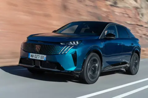 Blå Peugeot 3008 kör på en väg, redo för ett test.
