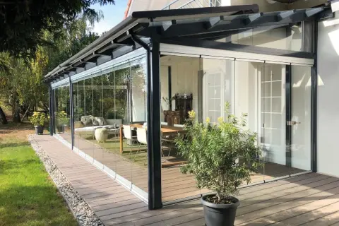 Porche acristalado con muebles de interior. Una idea para como cerrar un porche de forma económica y disfrutarlo todo el año.