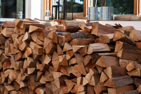 Ein großer Stapel gespaltenes Brennholz, bereit, um eine Holzmiete zu bauen.