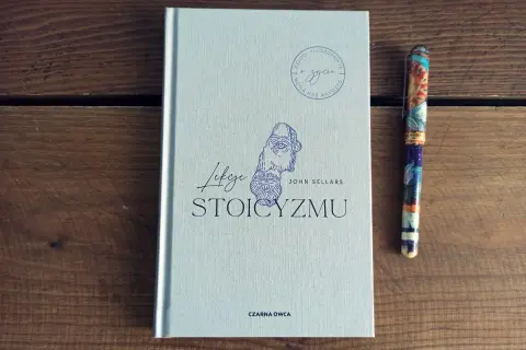 Książka "Lekcje stoicyzmu" Johna Sellarsa obok ozdobnego pióra. Inspiracja dla tych, którzy szukają mądrości w literaturze.