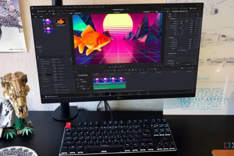 A computer monitor displays DaVinci Resolve, showing a goldfish in a retro neon landscape. This setup hints at a comparison between davinci resolve vs after effects for video editing.