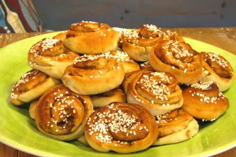 En hög med nybakade kanelbullar, perfekta att baka med mycket mjölk för extra saftighet. Strösslade med pärlsocker.
