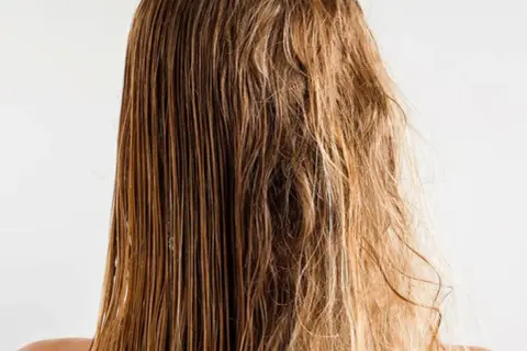 Cabello mojado y liso a un lado, y pelo roto y encrespado al otro, mostrando el contraste.