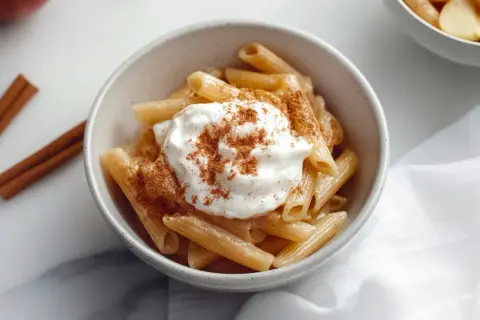 Penne makaron z jabłkami, polany śmietaną i posypany cynamonem. Aromatyczny deser, który zachwyca smakiem.