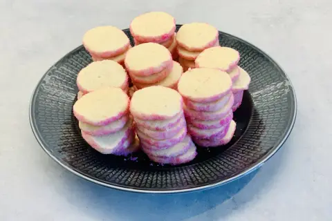 En hög med rosa och gula brysselkex på en svart tallrik. Perfekt för ett brysselkex recept!
