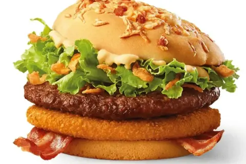Burger McRoyal z bekonem, sałatą, cebulką i sosem.