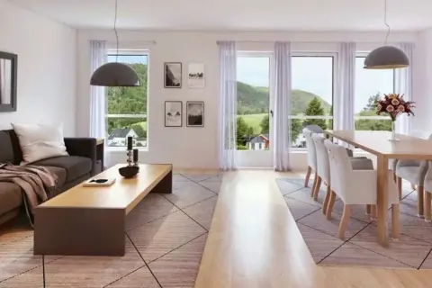 Soggiorno luminoso con divano, tavolino e zona pranzo. Ideale per capire dove posizionare il tavolo in soggiorno, vicino alle finestre per godere del panorama.