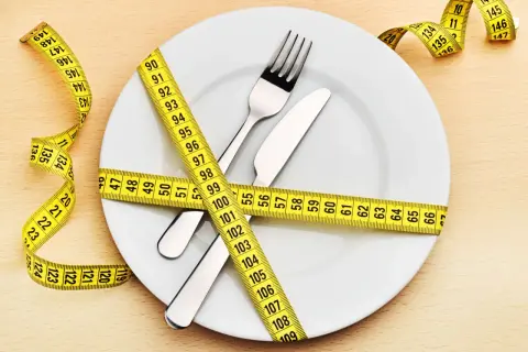 Une assiette avec couverts est entourée d'un mètre ruban jaune. La question "quel poids pour 1m60 femme" est implicite.