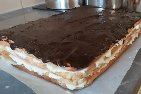 Pyszny, prostokątny tort Stefania z kremem i polewą czekoladową, gotowy do podania.