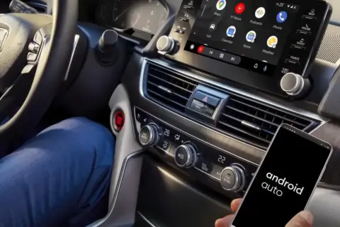 Conectar Android Auto sin cable es fácil. Un smartphone con la app muestra el sistema en la pantalla del coche.