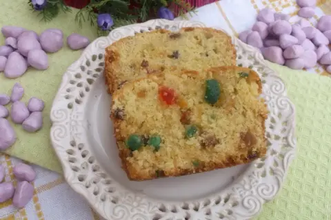 Keks stary przepis, z bakaliami i kandyzowanymi owocami, na ozdobnym talerzyku.