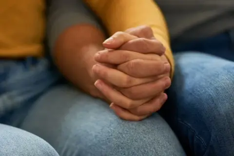 Zwei Hände halten sich fest. Die Frage, warum trennen sich depressive vom Partner, beschäftigt viele.