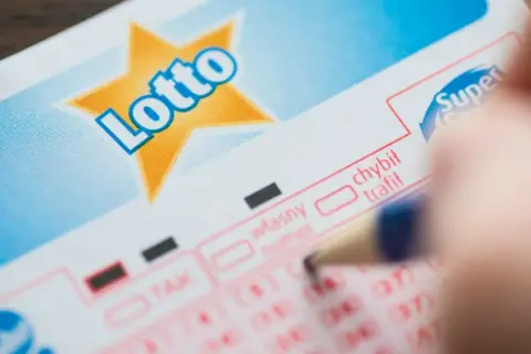 Długopis zaznacza opcję na kuponie Lotto. Zastanawiasz się, ile wynosi opłata za jeden zakład prosty w mini lotto?