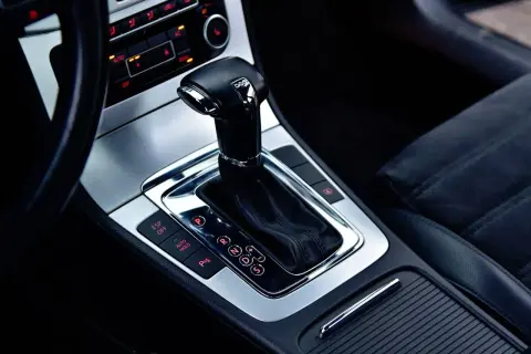 Błyszcząca dźwignia zmiany biegów skrzyni DSG w nowoczesnym samochodzie. Widoczne przyciski ESP, Auto Hold i P.